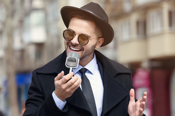 Canvas Print - Handsome man with microphone outdoors