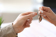© Pixel-Shot - Real estate agent giving key from new house to young man in office