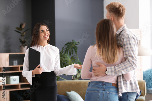 Fotografía Real estate agent showing young couple a new house