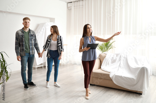 Fotomural Real estate agent showing young couple a new house