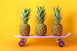 Ripe pineapples and skateboard on color background