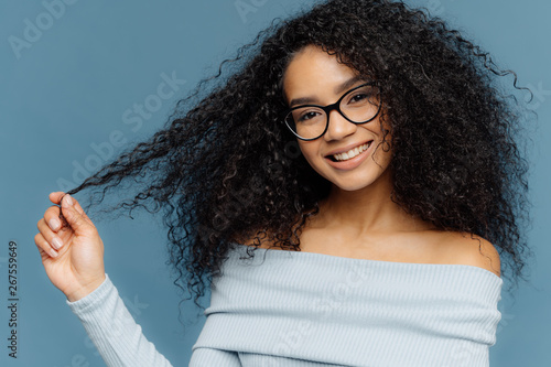 Horizontal Shot Of Lovely Smiling Afro American Woman Holds Tips