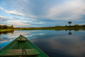 Traditional wooden boat floats on the Amazon river in the jungle. Amazon River Manaus, Amazonas, Brazil.