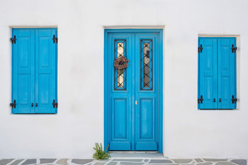 White house facade with traditional blue door on Paros island, Cyclades