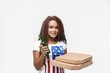 © Drobot Dean - Portrait of young african american woman holding pizza boxes and beer bottle during football game