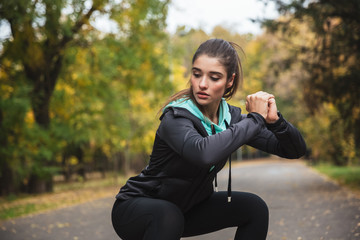 Wall Mural - Strong fitness woman outdoors in the park make exercises.