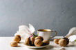 © Natasha Breen - Baci di dama homemade italian hazelnut biscuits cookies with chocolate cream served in ceramic plate with cup of espresso coffee and magnolia flowers over white marble table. Copy space