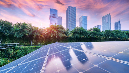 Wall Mural - ecological energy renewable solar panel plant with urban landscape landmarks in sunset