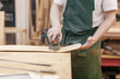© Rithor - Young american european guy carpenter is working on the design of a new unique wooden furniture in his workshop. Concepts of own production