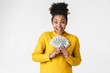 © Drobot Dean - African excited emotional happy woman posing isolated over white wall background holding money.