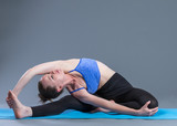 Fototapeta  - Beautiful sporty fit young woman practices yoga asana.