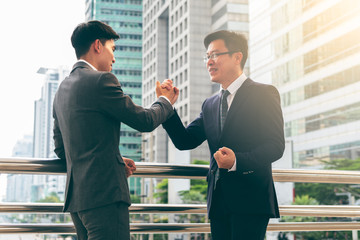 Wall Mural - Male businessmen coordinate showing the power And cooperate In doing business To be successful with blurred soft of the tall building in city, to teamwork concept.