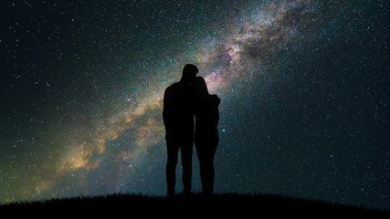 Wall Mural - The couple hugs on the starry sky background. time lapse