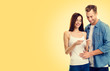 © vgstudio - Photo of couple, finding out results of a pregnancy test, over yellow color background