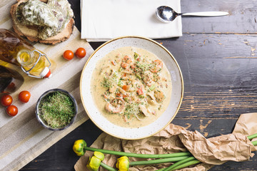 Wall Mural - creamy seafood soup on wooden table