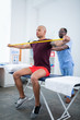 © Viacheslav Yakobchuk - Bald sportsman doing exercises for arms visiting sports therapist