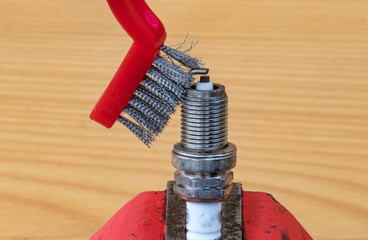 Mechanical spark plug cleaning technology with a metal brush