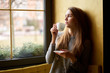 © Kiryl Lis - Young attractive girl drinking coffee or tea  in the cafe and looking out the window.