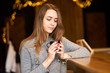 © Kiryl Lis - Attractive charming cute woman with long hair, natural make-up and friendly smile siting in the cafe and holding black cup of coffee.