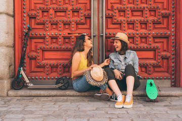 Young women gay couple looking and smiling each other in a red door background. Same sex happiness and joyful concept.