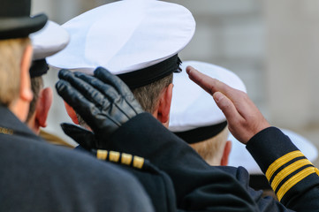 Royal Navy officers salute during Remembrance Day commemorations.