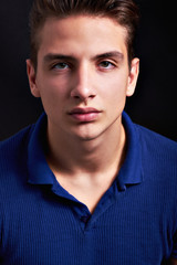 Wall Mural - Elegant young handsome man posing on black background