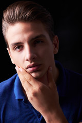 Wall Mural - Elegant young handsome man posing on black background