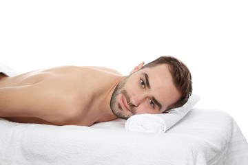 Sticker - Handsome man relaxing on massage table against white background. Spa service