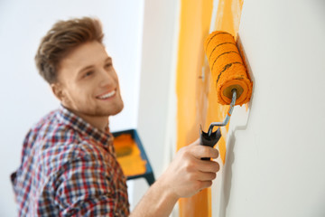 Canvas Print - Happy young man painting wall indoors. Home repair