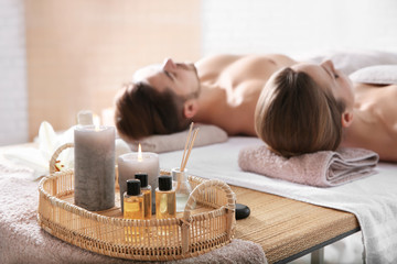 Poster - Young couple with spa essentials in wellness center