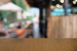 © Wanda - Empty dark wooden table in front of abstract blurred bokeh background of restaurant . can be used for display or montage your products.Mock up for space.
