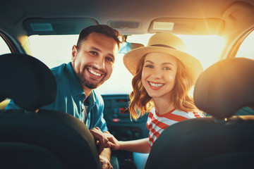 happy couple man and woman in car traveling in summer.