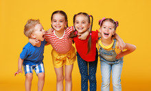 Group Of Cheerful Happy Children On Colored Yellow Background.
