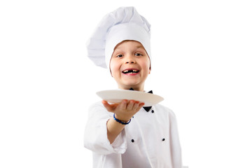 Wall Mural - cute funny boy chef in uniform holds a clean empty white plate in his hand