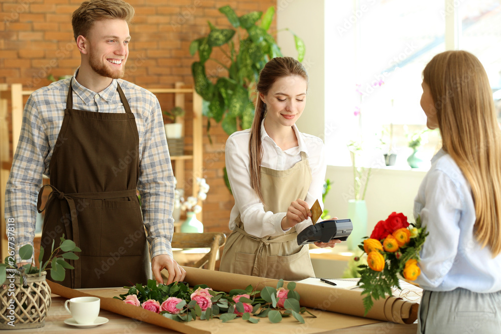 Woman paying for order in flower shop
