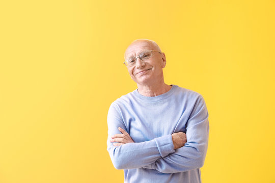 Portrait of happy elderly man on color background