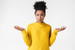 © Drobot Dean - Beautiful young african confused woman posing isolated over white wall background.