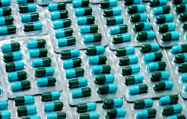 Wall Mural - Amoxicillin capsule in blister pack. Pharmaceutical industry. Green-blue antibiotic capsule pills. Antibiotics drug resistance concept. Penicillin drug for treatment infection. Health care products.