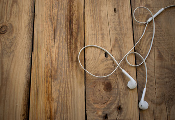 white telephone headphones on a wooden desktop