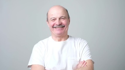 Wall Mural - Handsome senior man in white t-shirt laughing