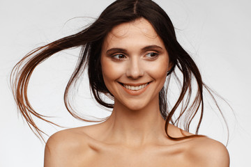 Wall Mural - Portrait of a young beautiful woman with hair flying from the wind and bare shoulders