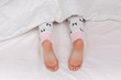 © Rychko Yevhen - Pair of kid bare feet in bed on white sheets