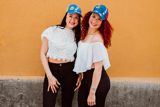.Two beautiful Venezuelan women in a neutral background with a significant cap of their country, excited with a change and a free Venezuela.