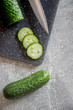 Ogórek zielony gruntowy, na desce do krojenia z nożem