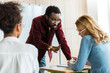 © LIGHTFIELD STUDIOS - african american teacher in glasses talking to student in university