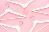 Fototapeta Uliczki - White hangers on pastel pink background