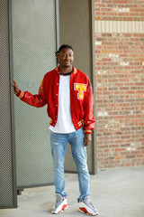 Wall Mural - Male High School Senior in Red Letterman Jacket for Sports standing in an Urban Area