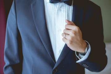 The groom caught his blue suit. That his finger have a wedding ring.