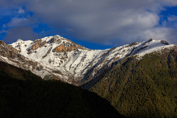 Wall Mural - Snow mountains, epic snow covered mountain range - Daocheng Yading Nature Reserve. Ganzi, Garze, Kham Tibetan area of Sichuan Province China. Dramatic lighting during sunset, Clouds and Sky