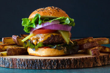 Front facing view of a fully loaded cheese burger ready for eating.